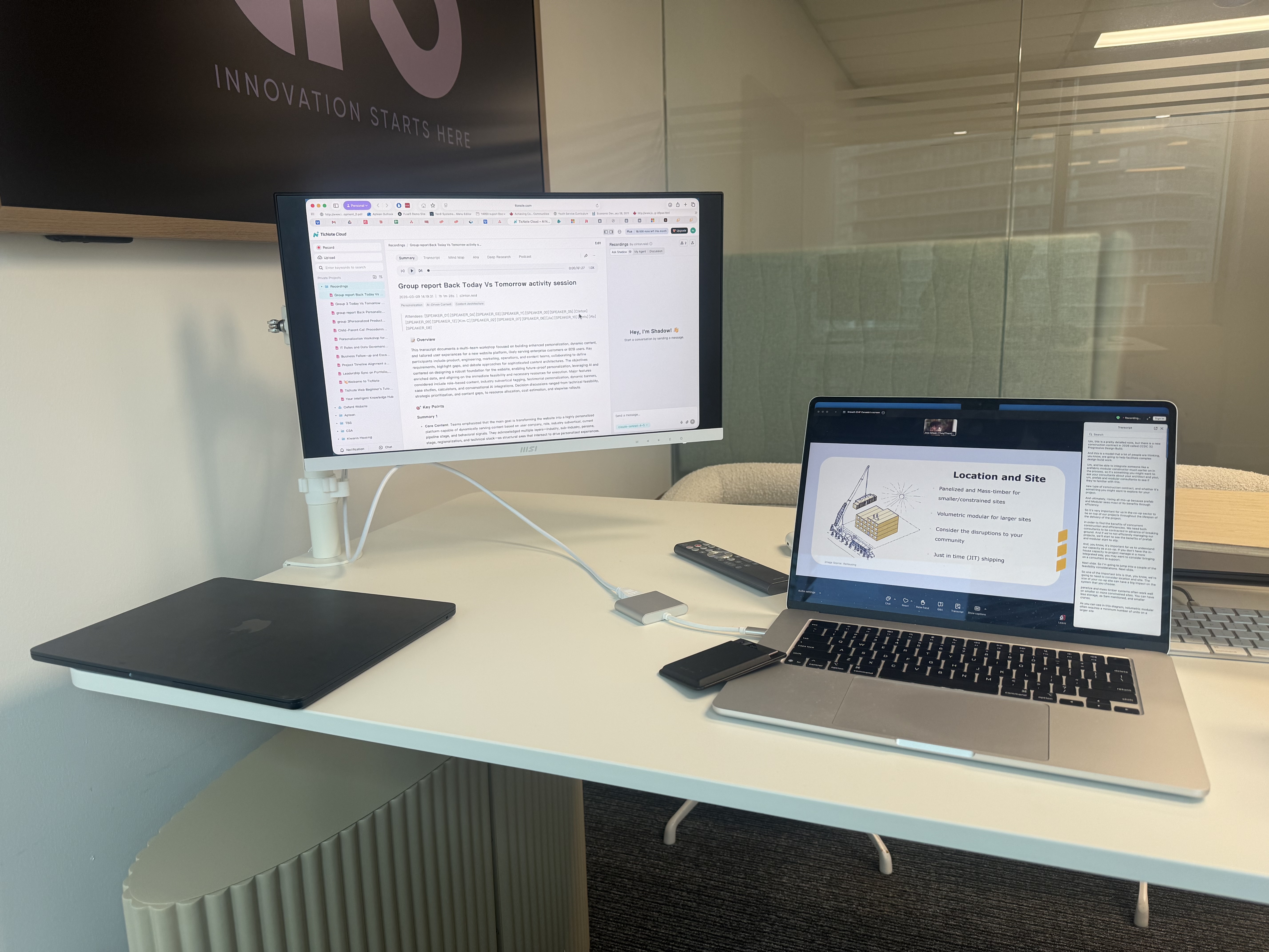 Clinton Reid's clean desk setup with two monitors showing documents and a presentation slide
