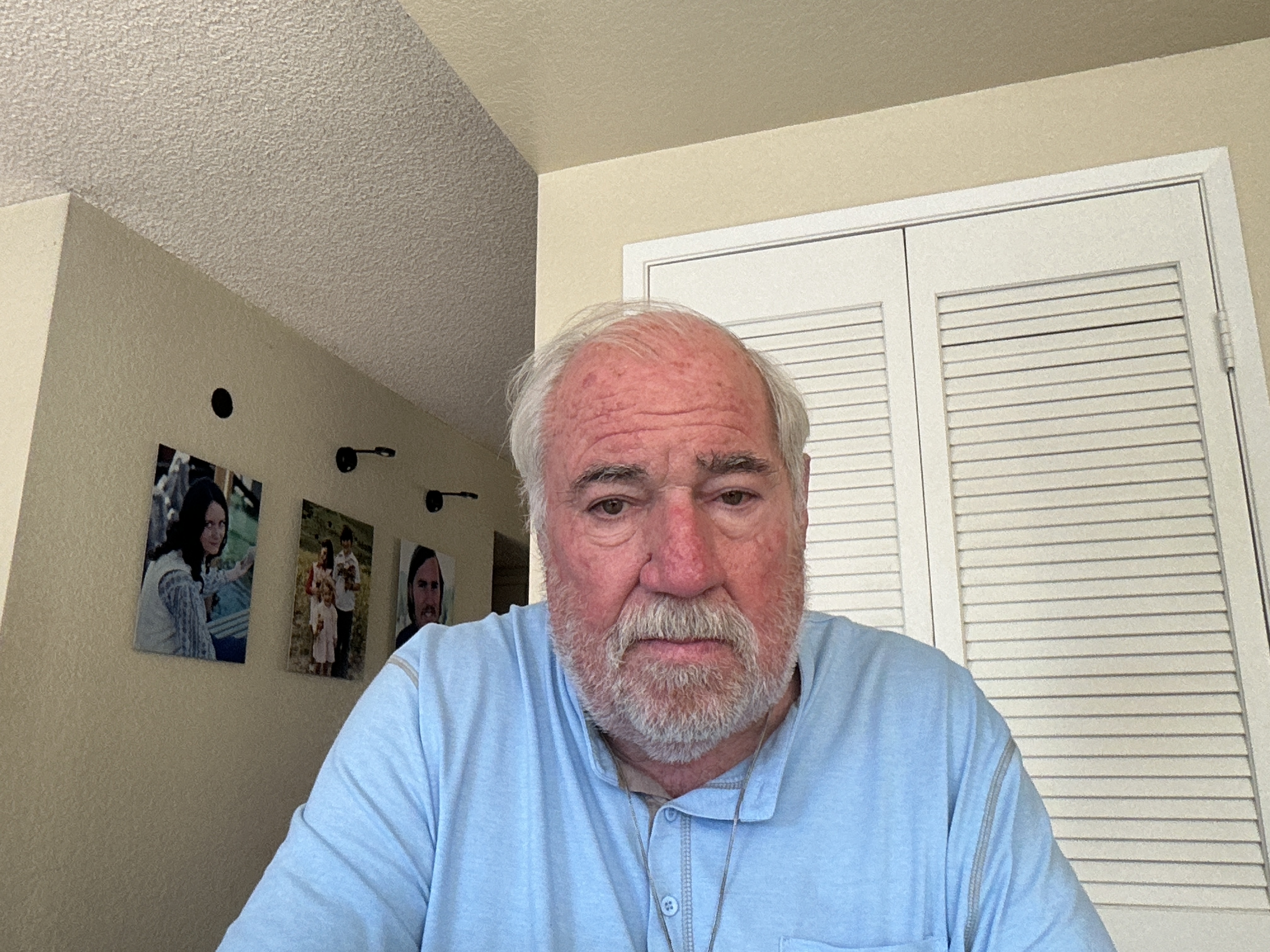 John C. Henberger Jr., CEO coach and author, portrait at home with framed photos on wall
