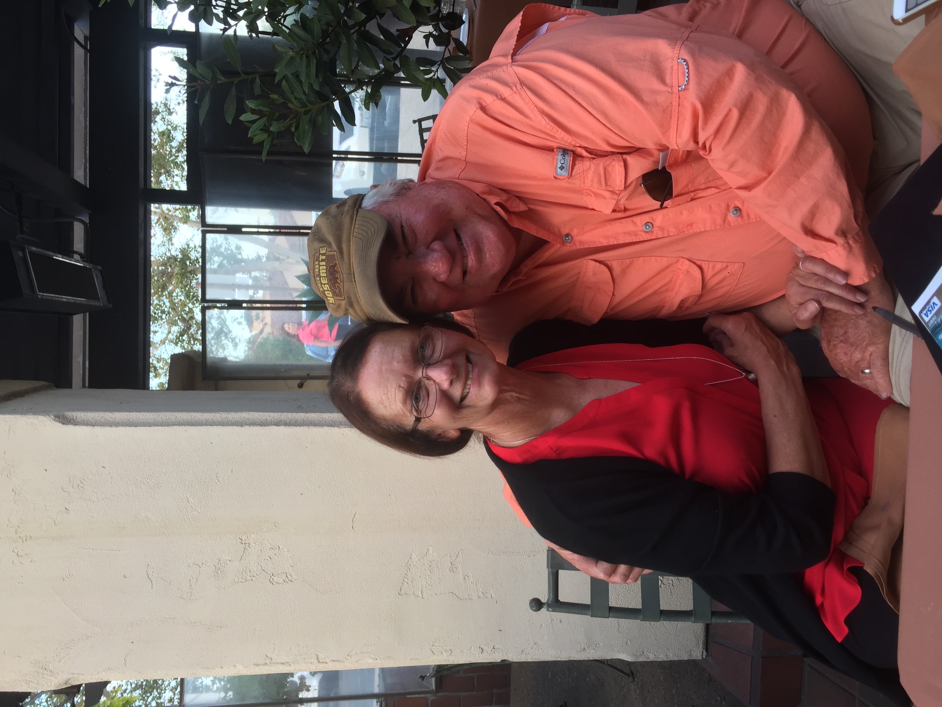 John Henberger and his wife relaxing together at an outdoor patio table, smiling